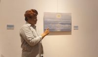 Foto: Seniman Bali I Wayan Karja dan Karya teranyar miliknya "Surya Segara Rupa". Sumber: Komang Ari/Wacanabali.com