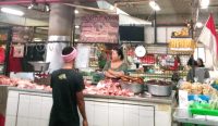Foto: Ketut Nonik, salah satu pedagang daging babi di pasar Badung saat sedang menunggu pembeli, Rabu (20/12/23). Sumber: Yulius Nipu/wacanabali.com