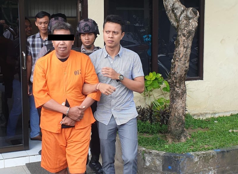 Foto: Ws sang Residivis Penipuan saat di gelandang petugas kembali ke sel usai Pers Release di Aula Mapolres Jembrana. Kamis (4/1/24). Sumber Foto : Yus/wacanabali.com