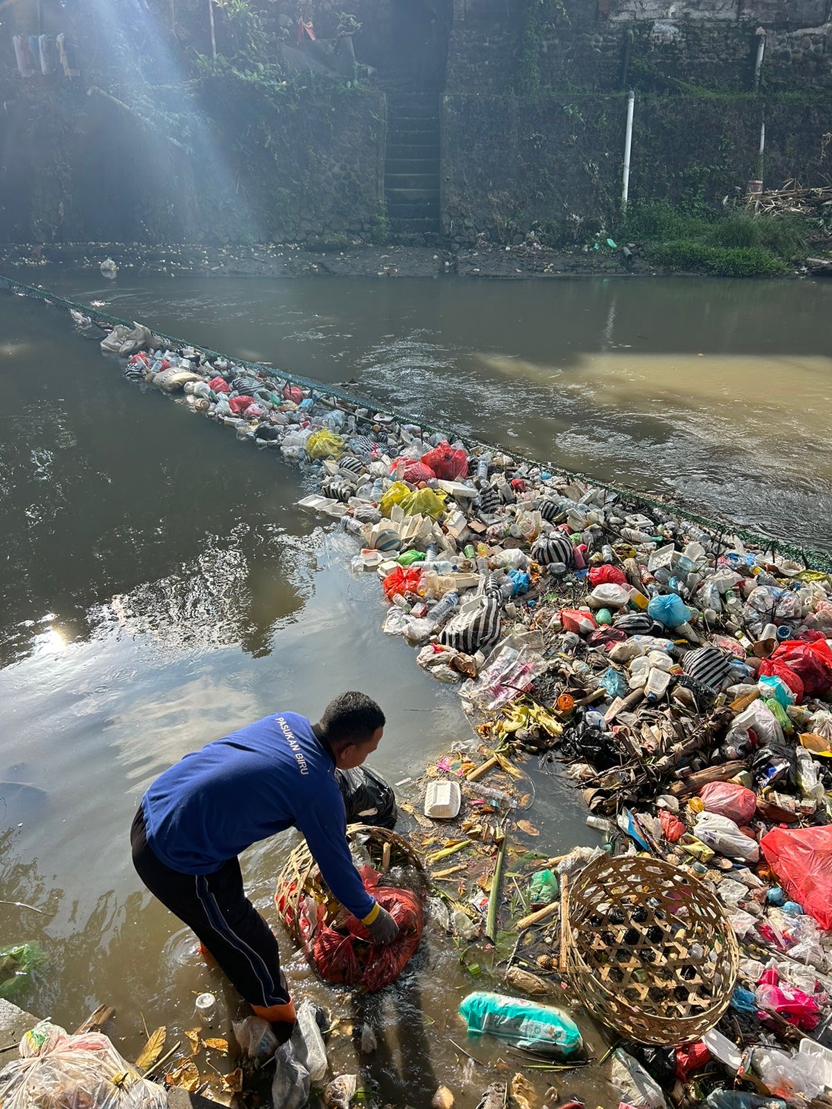 Foto: Petugas membersihkan sampah-sampah plastik di sungai. Sumber: Istimewa.