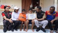 Foto: Bupati Satria menyerahkan bantuan sosial kepada anak yatim piatu, Gede Eka Mahayana, di Desa Nyalian, Kecamatan Banjarangkan, Minggu (5/10).