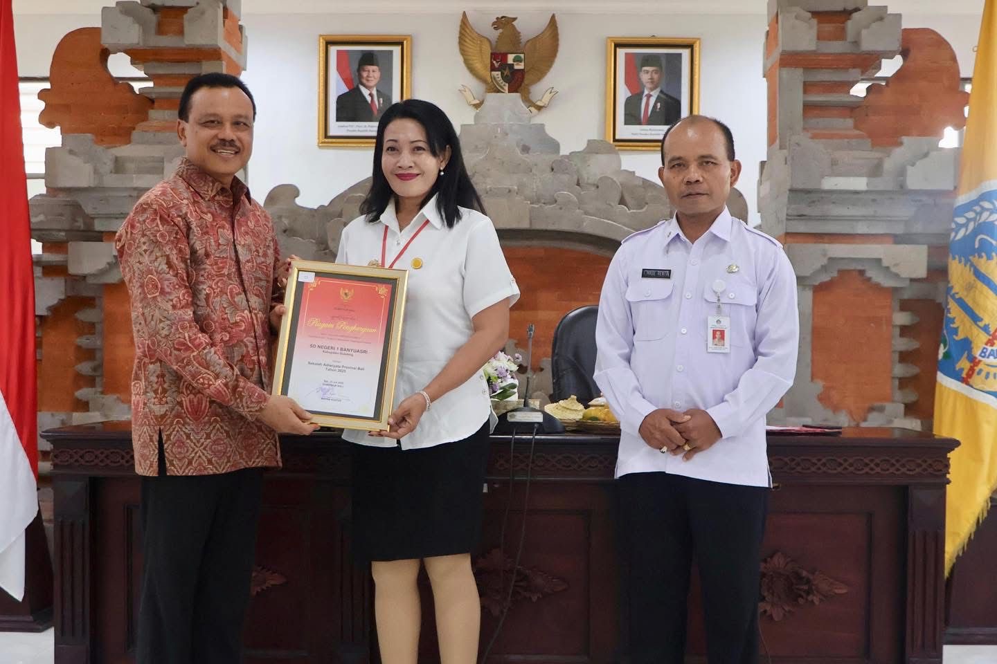 Sekretaris Daerah Provinsi Bali, Dewa Made Indra, menyerahkan penghargaan Sekolah Adiwiyata Provinsi Bali 2025