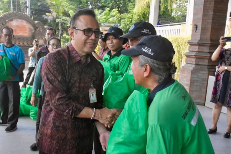Foto: Wali Kota Denpasar I Gusti Ngurah Jaya Negara saat menyerahkan secara simbolis bantuan sembako kepada petugas kebersihan DLHK Kota Denpasar di Lobby Gedung Dharma Negara Alaya, Selasa (14/10/25). Sumber: Istimewa.