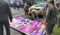 Caption: Satpol PP Kabupaten Jembrana menertibkan sejumlah reklama kadaluarsa di jalan Denpasar Gilimanuk, Rabu (11/02/26)