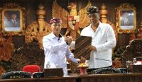 Bupati Klungkung I Made Satria menyerahkan dokumen kepada Ketua DPRD Kabupaten Klungkung saat Rapat Paripurna II terkait Penyampaian Pendapat Akhir Bupati terhadap Ranperda tentang Perubahan atas Perda Nomor 8 Tahun 2023 tentang Pajak Daerah dan Retribusi Daerah di Gedung Sabha Nawa Natya DPRD Kabupaten Klungkung, Jumat (6/3).
